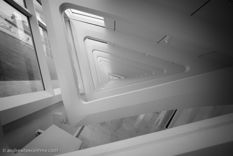 Abstract view down a repeating white architectural corridor with triangular openings